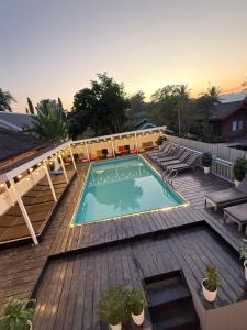 a swimming pool on top of a wooden deck at Luang Prabang Sunset Hostel in Luang Prabang