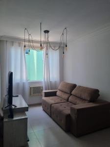 a living room with a couch and a tv at Bem vindo ao APTO 403 in Florianópolis