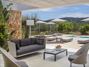 sala de estar con sofá, sillas y piscina en Villa in Ibiza with Mountain Views & Pool, en Santa Eulària des Riu