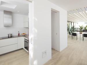 cocina con armarios blancos y comedor en Villa in Ibiza with Mountain Views & Pool, en Santa Eulària des Riu