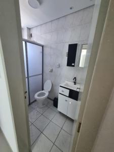 a white bathroom with a toilet and a sink at Bem vindo ao APTO 403 in Florianópolis