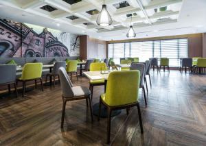 a dining room with tables and chairs and a mural at Atour Hotel Shanghai Xinzhuang in Shanghai