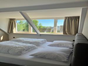 a bedroom with three beds and a window at Group accommodation for 36 guests in Scherpenzeel