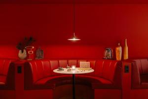 a red room with a red couch and a table at NYX Hotel Amsterdam Rembrandt Square in Amsterdam