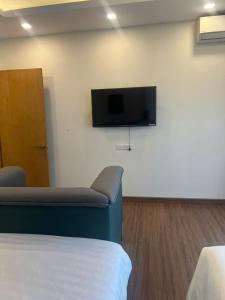 a room with a bed and a tv on a wall at FLC Quy Nhơn-Hotel View Biển-TT Thành Phố-Hồ Bơi 4 Mùa-QN Apartment in Quy Nhon