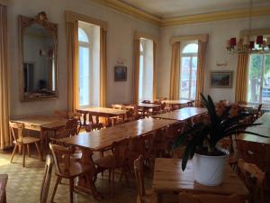 un restaurante con mesas y sillas de madera y un espejo en Hotel Quellenhof, en Scuol