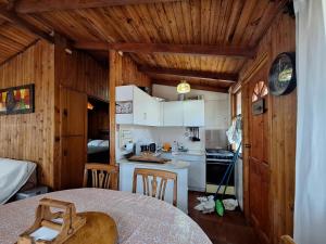 uma cozinha com paredes de madeira e uma mesa num quarto em Cabaña en el Canelillo em Algarrobo mais 6 fotografias
