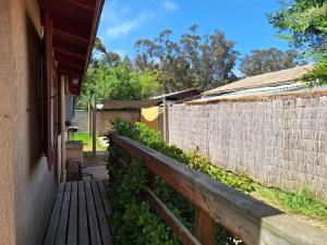 uma passarela de madeira ao lado de uma cerca de tijolos em Cabaña en el Canelillo em Algarrobo