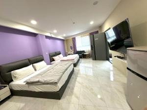 a bedroom with two beds and a flat screen tv at Strawberry Station in Dahu
