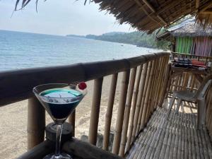 a drink sitting on a balcony with a view of the ocean at Satosa Beach Resort in San Joaquin