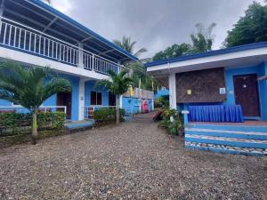 a blue and white building with palm trees in front of it at Satosa Beach Resort in San Joaquin
