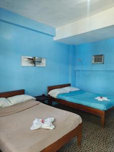 two beds in a room with blue walls at Satosa Beach Resort in San Joaquin