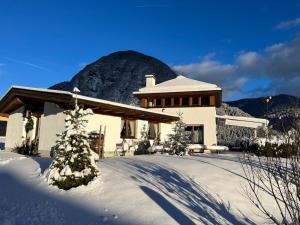 a house in the snow with a mountain in the background at Chalet Leutasch with Ski Trail & Mountain Views in Leutasch