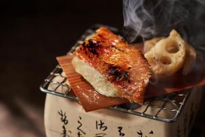 Un trozo de comida en un plato con humo. en Ochiairo, en Izu