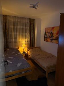 um quarto com 2 camas, um candeeiro e uma janela em The Hot Spot em Kosovo Polje