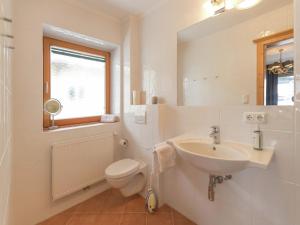 Un baño blanco con lavabo e inodoro. en Chalet in Ellmau near Ski Lift, en Ellmau
