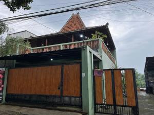a house with a gate and a roof at Villa Murah Joglo Sariwangi in Cihanjuang 1