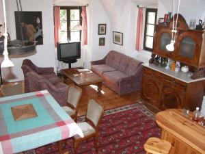 uma sala de estar com um sofá e uma TV em Berg Castle Klösterle em Zedlitzdorf