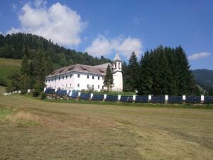 um grande prédio branco com um trem em um campo em Berg Castle Klösterle em Zedlitzdorf