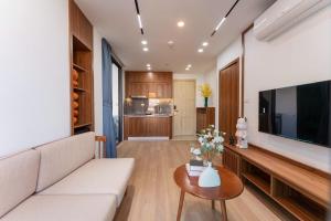 a living room with a couch and a tv and a table at Caelistay in Hanoi