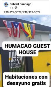 Humacao Guest House 4 في هوماكاو: لافتة على جانب منزل عليها علم