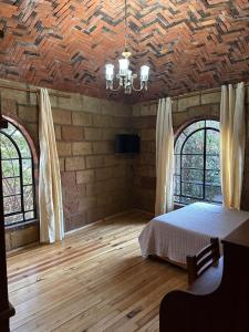 a bedroom with a bed and two windows and a ceiling at Casa Rústica del pedregal in Mexico City