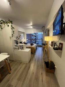 a living room with a bed and a tv on a wall at Urquiza Suite Premium Rental in Buenos Aires