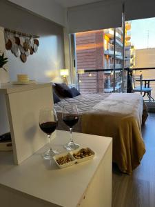 Una habitación con dos copas de vino y una cama. en Urquiza Suite Premium Rental, en Buenos Aires