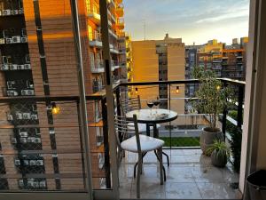 a balcony with a table and chair on a balcony at Urquiza Suite Premium Rental in Buenos Aires