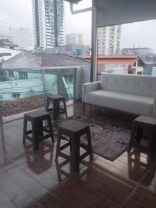 a living room with a couch and stools at Villa Hostel in Belém