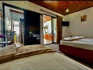 Villa Oropéndola Sarapiquí في Colonia Carvajal: غرفة نوم بسريرين وشرفة