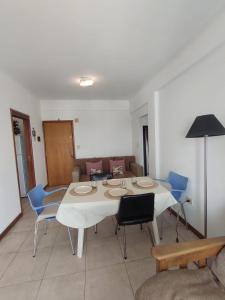 a dining room with a white table and blue chairs at Torre 1 Estadio Unico in La Plata