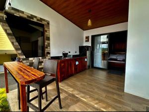 Villa Oropéndola Sarapiquí في Colonia Carvajal: غرفة معيشة مع طاولة خشبية وتلفزيون