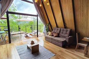 uma sala de estar com um sofá e uma mesa em Cabana El Shaday em Pirenópolis