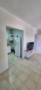 eine leere Küche mit einem Kühlschrank und einem TV in der Unterkunft Dpto céntrico san lorenzo in San Lorenzo