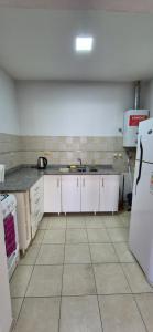 eine Küche mit weißen Schränken und einem weißen Kühlschrank in der Unterkunft Dpto céntrico san lorenzo in San Lorenzo