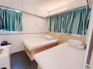 Un baño pequeño con dos lavabos y un espejo. en Joy Hella Inn, en Hong Kong 3 fotos más