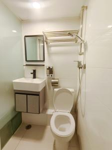 Un baño blanco con inodoro y lavabo. en Joy Hella Inn, en Hong Kong