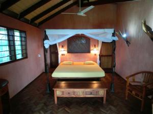 a bedroom with a bed and a table in a room at Residence Tsara Vintana in Ambatoloaka