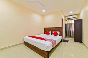 a bedroom with a large bed with red pillows at Hotel O Poddar Inn in Dispur +31 photos