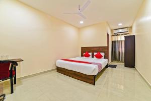 a bedroom with a bed with red pillows at Hotel O Poddar Inn in Dispur