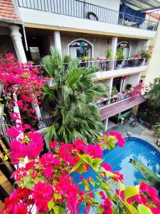 a courtyard with pink flowers and a swimming pool at Villa Full House in Vũ Lâm