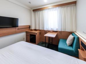 a hotel room with a bed and a television at Nishitetsu Inn Shinjuku in Tokyo +48 photos