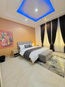 Un dormitorio con una cama con techo azul. en StayatMargarets, en Abuja