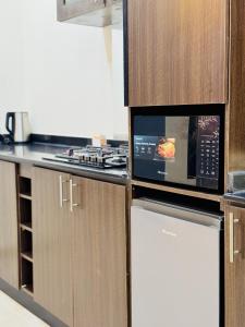 una cocina con nevera y microondas en StayatMargarets, en Abuja