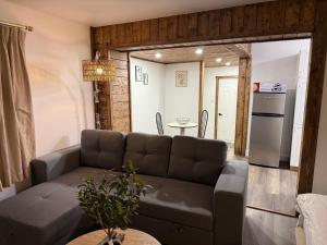 Hôtel Saint-Côme في Saint Come: غرفة معيشة مع أريكة ومطبخ