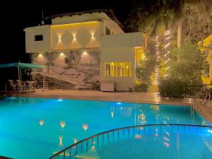 Tiger Heaven Resort في Tāla: مسبح امام بيت بالليل