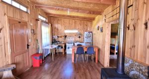 uma sala de jantar e cozinha de uma pequena casa em Cabaña Alto Puelo em Puelo