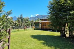 um quintal com uma casa e uma cerca em Cabaña Alto Puelo em Puelo