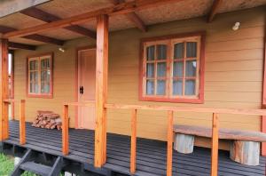 um alpendre frontal de uma casa de madeira com uma janela em Cabaña Alto Puelo em Puelo
